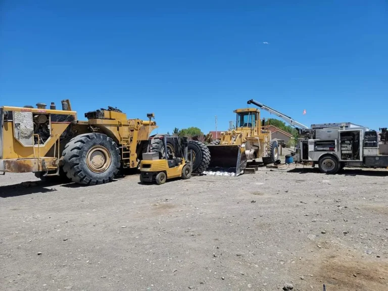 A Horizon Equipment Repair crane truck lifts a grader so that the wheel can be replaced